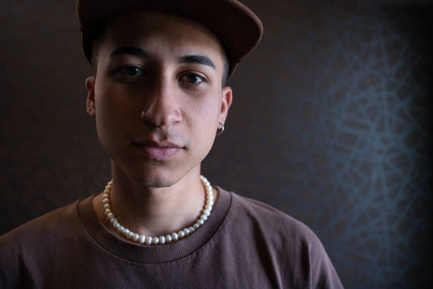 Young man wearing trendy pearl necklace at music festival